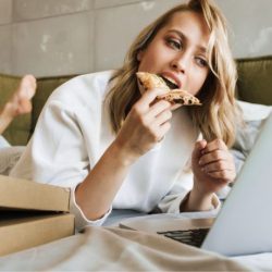 nő eszik laptop előtt
